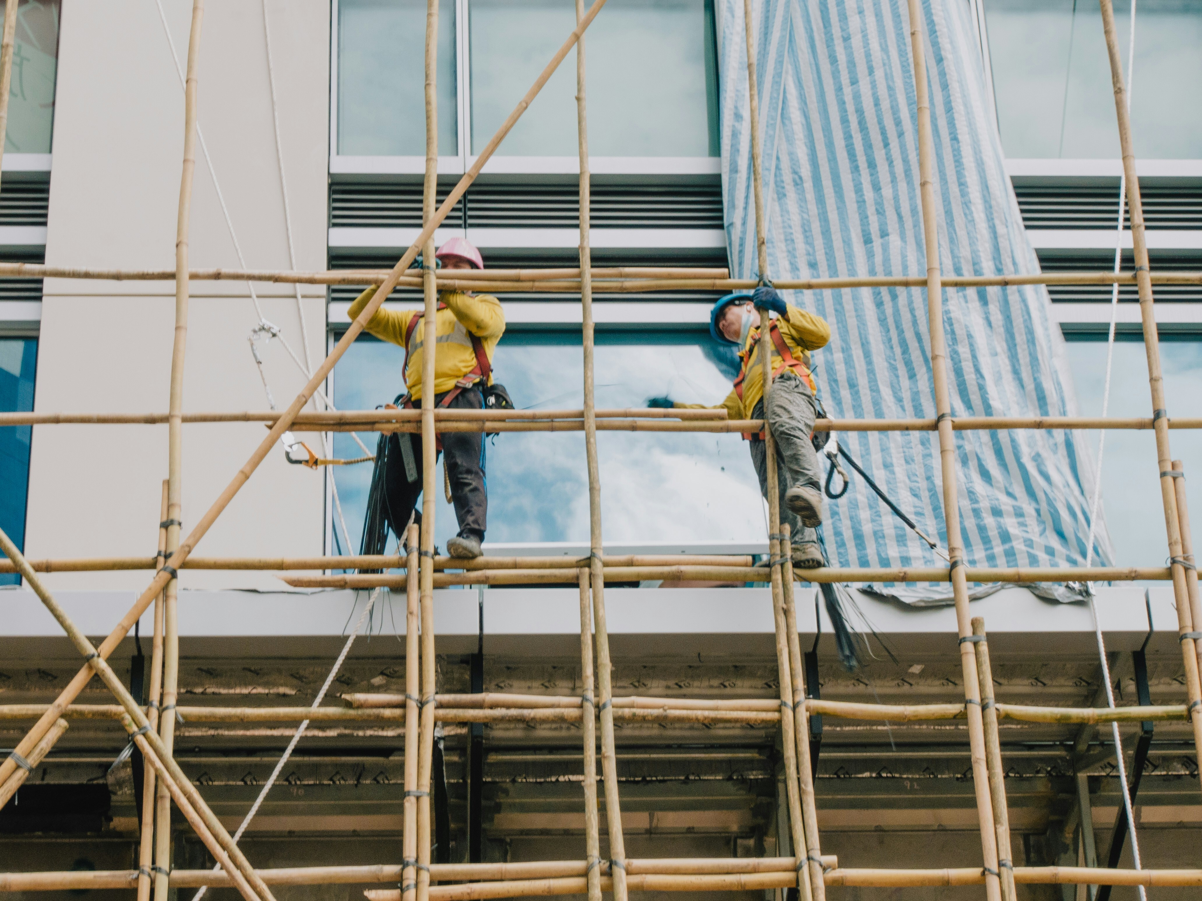 Construction workers in Hong Kong affix bamboo scaffold to a building