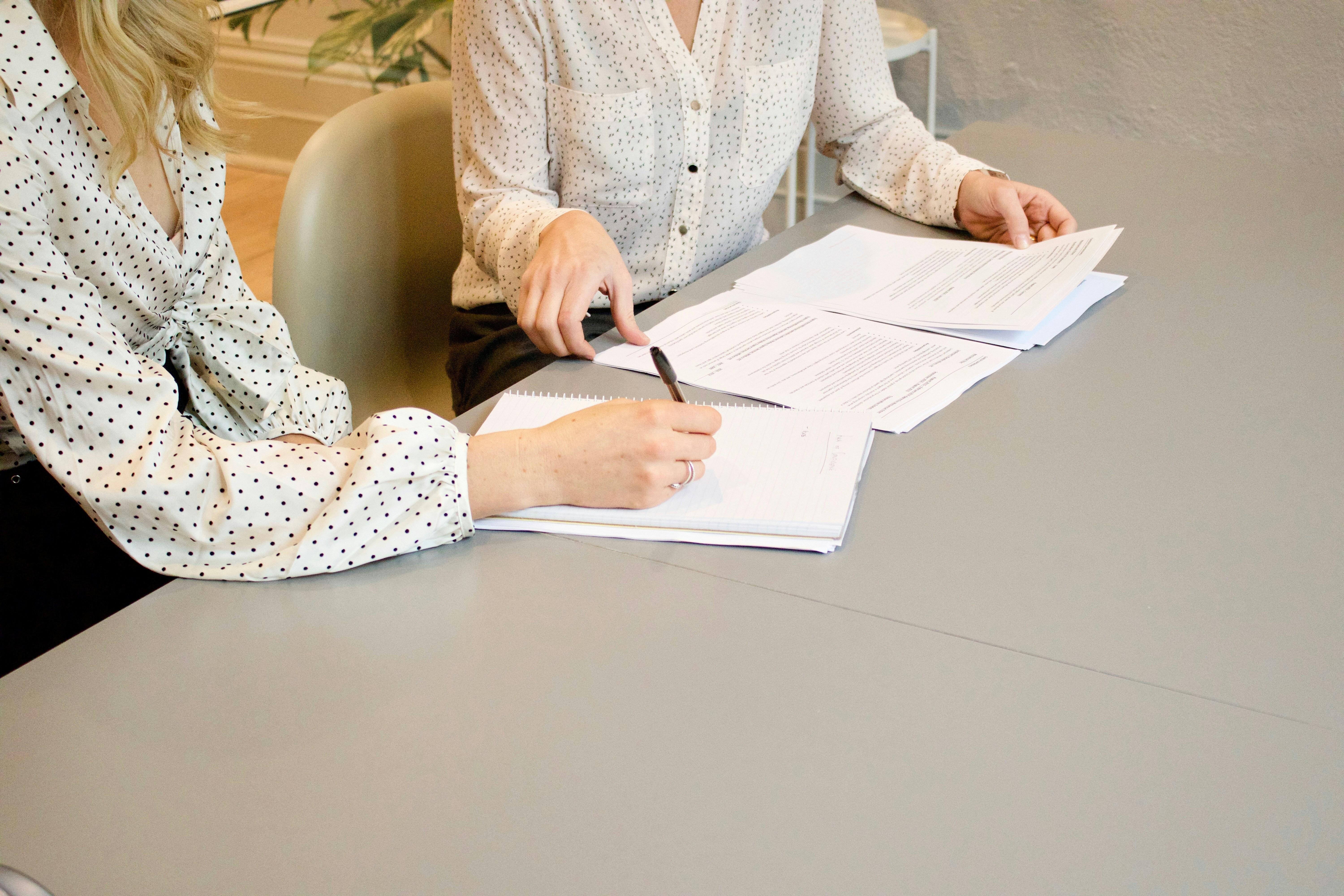 Two women discussing paperwork that they are completing