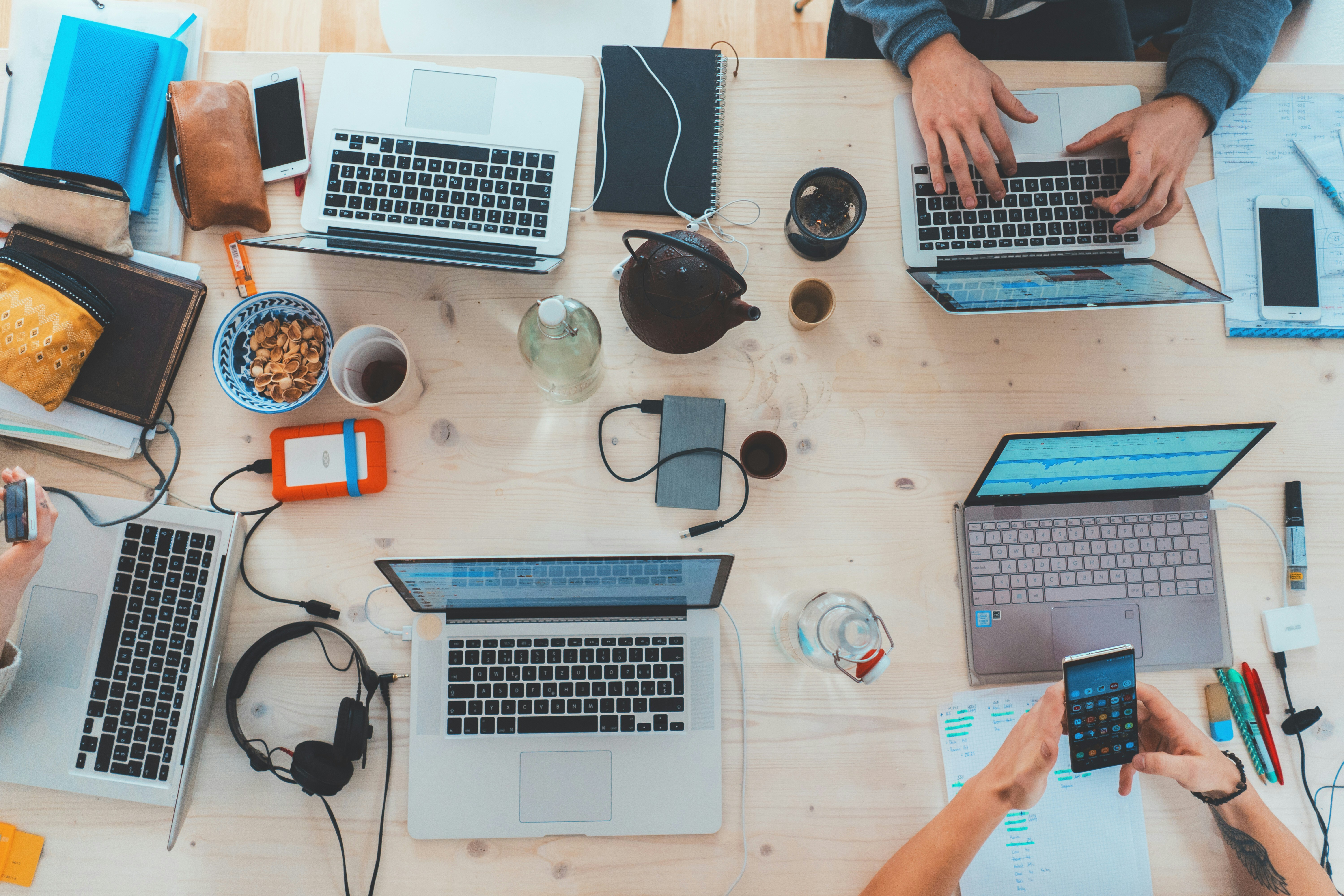 Workers with laptops sitting at a messy desk