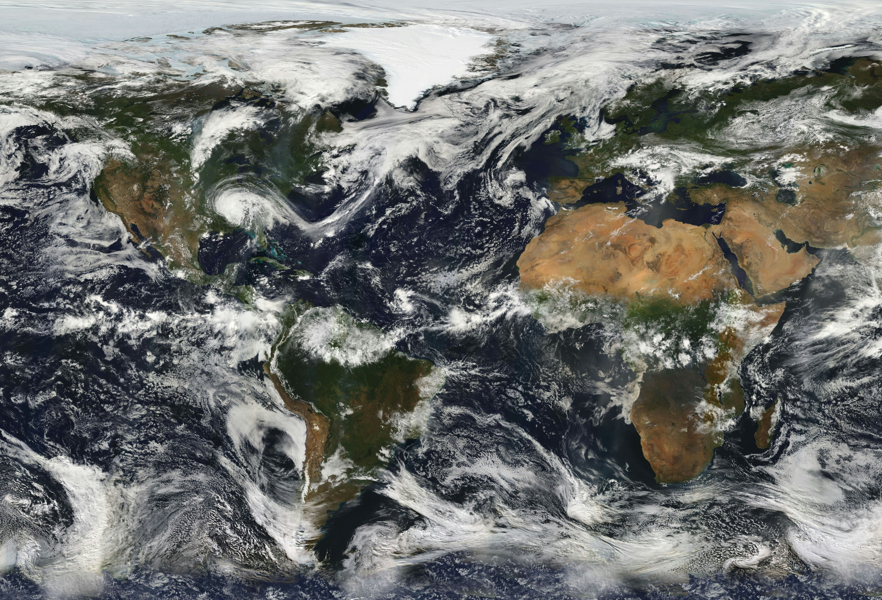 A space view of earth with clouds visible. The picture is looking at the Americas, Europe, Africa, the Middle east and part of asia.,
