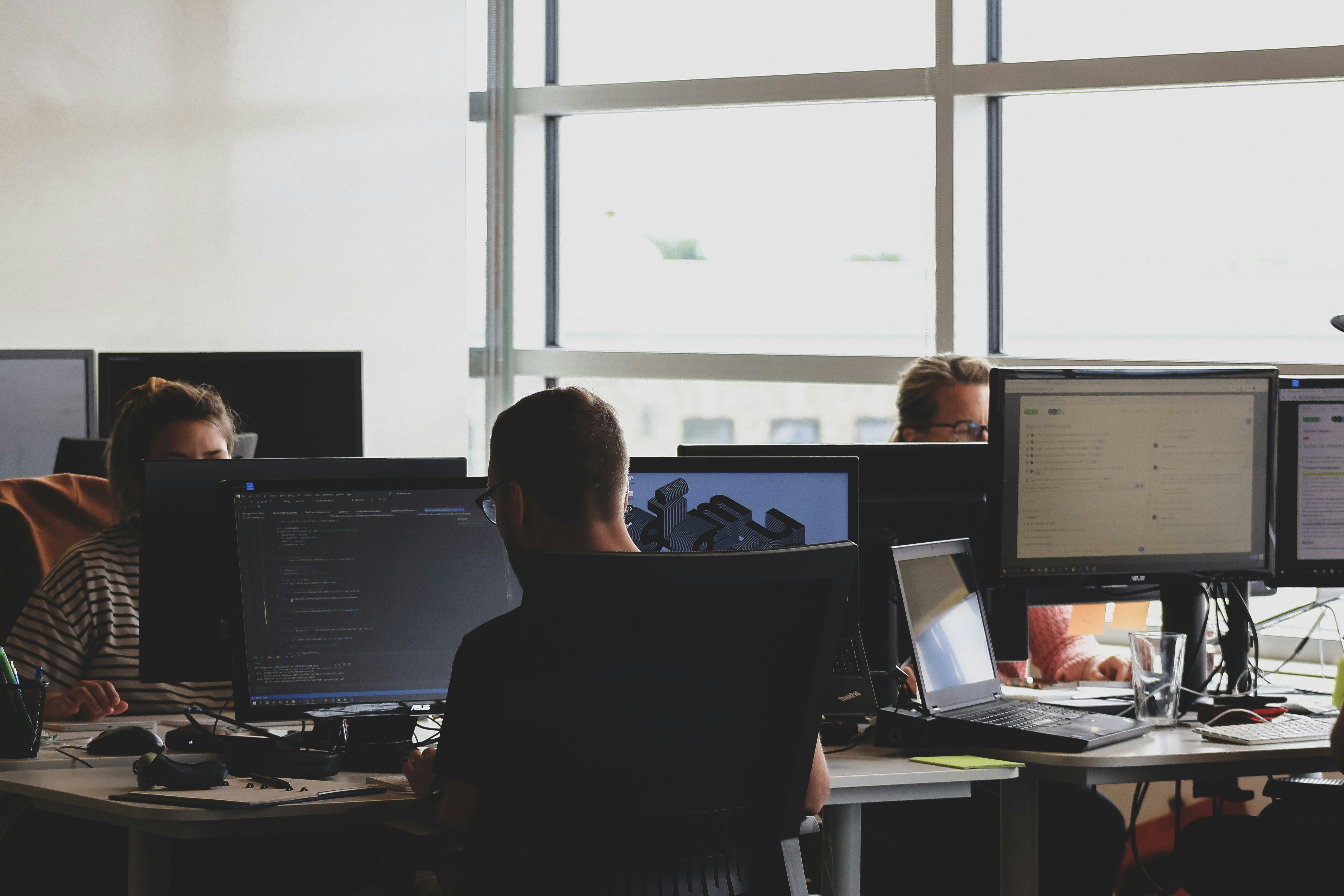 A group of tech workers at desks in front of computers