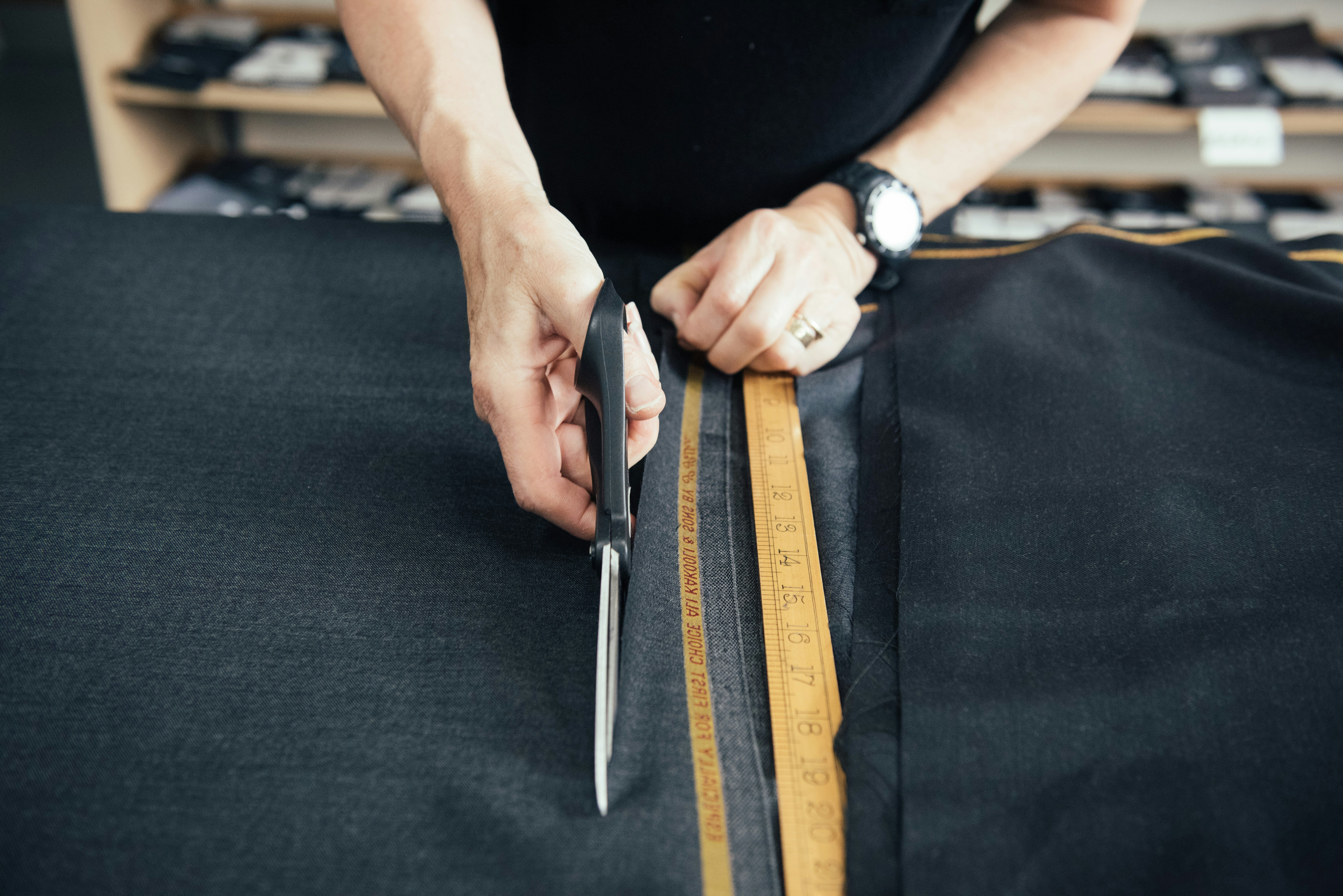 A tailor cutting cloth to make a bespoke suit